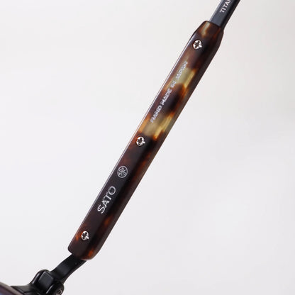 SATO Erakis col.B/T-1 リムとサイドの細部。マットブラックのチタン、べっ甲柄のリム、ダークブルーのグラデーションレンズ。